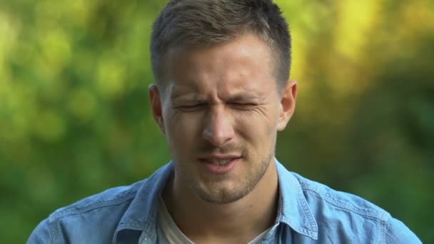 Młody mężczyzna masujący świątynie odczuwający silny ból głowy, problemy z naczyniami — Wideo stockowe
