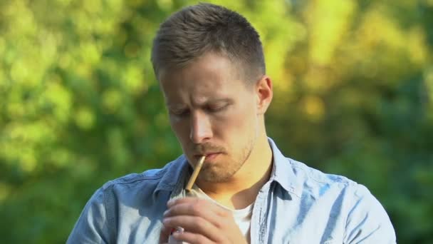 Handsome man lighting cigarette and inhaling bitter smoke, resting outdoor — Stock Video