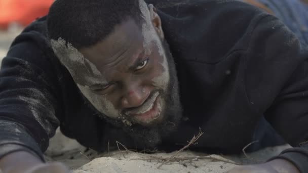 Hombre afro-americano llorando mirando la cámara en la costa del mar, víctima de una catástrofe — Vídeo de stock