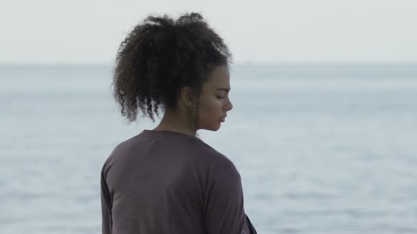 Upprörd kvinnlig flykting sitter på havskusten nära båten, fly från hemlandet — Stockvideo