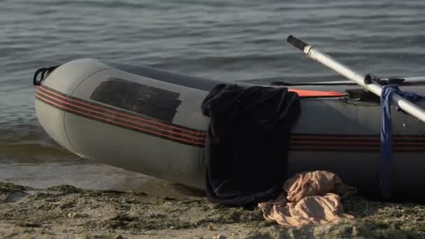Perahu dengan pakaian di pantai laut, bertahan hidup setelah kapal karam, menyelamatkan hidup — Stok Video