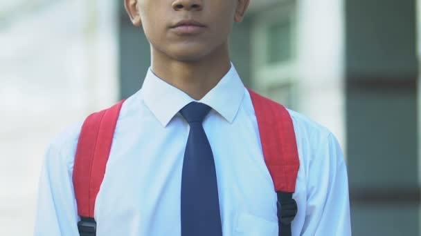 Schüler im Anzug, der widerwillig seinen Rucksack anpasst, ungeliebtes Studienkonzept, Nahaufnahme — Stockvideo