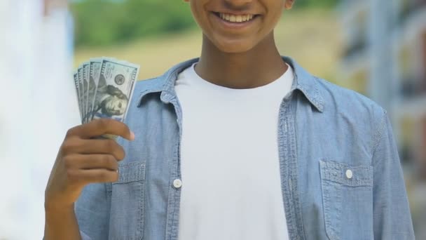 Menino adolescente feliz mostrando pacote de dólares, economia de dinheiro para o sonho, vitória loteria — Vídeo de Stock