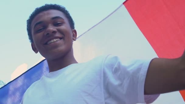 Fransız bayrağı sallayan Afro-Amerikalı genç çocuk, spor hayranı, vatansever genç. — Stok video