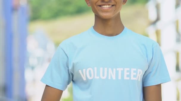Voluntario sonriente mostrando pulgares hacia arriba, ayuda humanitaria, bondad de la humanidad — Vídeo de stock