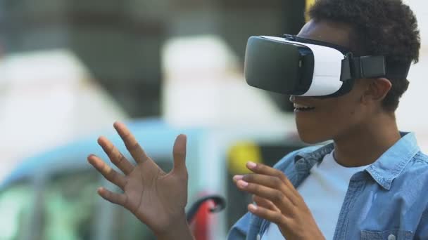 Garoto adolescente afro-americano excitado usando fone de ouvido VR, tecnologias modernas, futuro — Vídeo de Stock