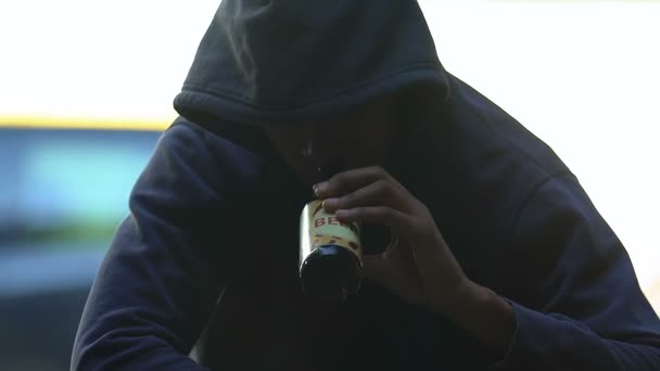 Алкоголь наркоман афро-американський хлопець підліток п'є пиво на відкритому повітрі, проблеми — стокове відео