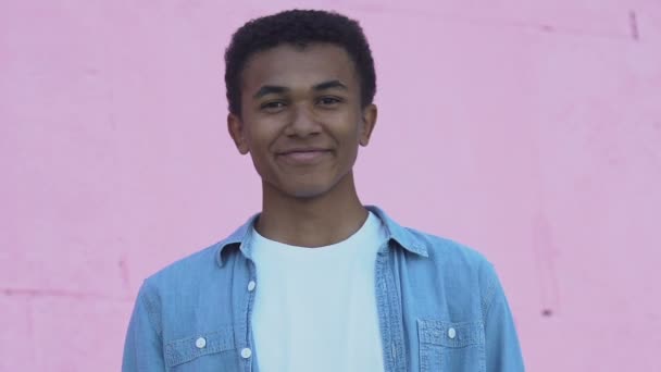 Alegre afroamericano adolescente sonriendo a la cámara, estado de ánimo positivo — Vídeos de Stock