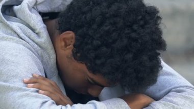 Genç Afro-Amerikan fakir genç erkek. Üzülerek kameraya bakıyor. Sosyal güvensizlik.