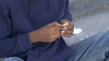 Zavallı yaralı afro-amerikan erkek, ellerinde dolar ve para sayıyor, parasızlar.