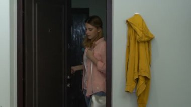 Genç kadın kapıyı açıp daireye giriyor, mutlu ve rahat hissediyor