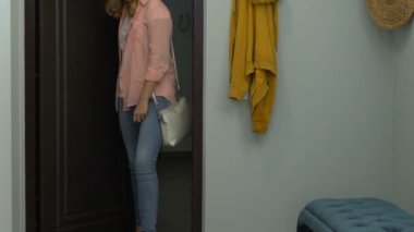 Üzgün genç kadın eve geliyor, ayakkabılarını çıkarıyor ve kapının yanında puf üzerinde oturuyor