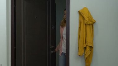 Mutsuz bitkin kadın kapıyı açma ve iş gününden sonra eve geliyor, fazla mesai