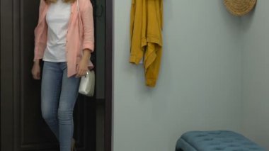 Genç yorgun bayan eve gelen giriş kapısını açıyor ve üzüntüsi kapalı ayakkabı alıyor