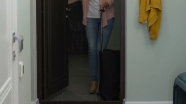 Uzun bir yolculuktan sonra eve gelen bavulu ile genç güzel kadın, mutlu hissediyorum