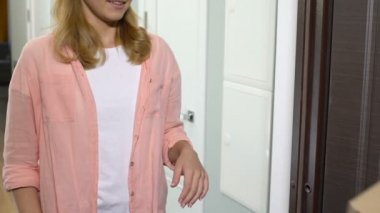 Güzel genç kadın kapı açma ve teslimat için pizza ödeme kurye alarak