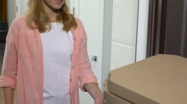 Çekici kadın giriş kapısını açma ve pizza alarak, teslimat adam ödeme