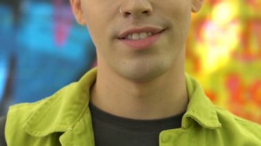 Pleased caucasian young man with nose ring posing on camera, fashion, close-up