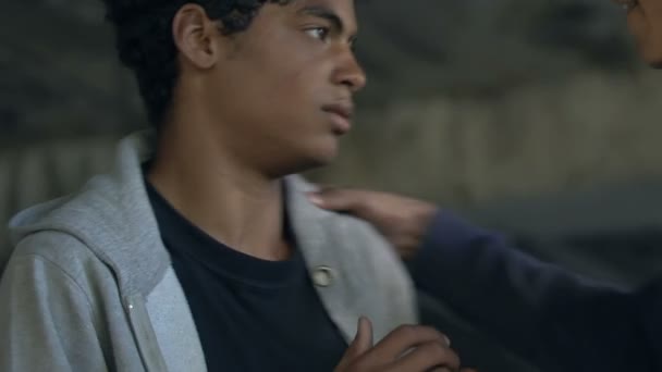 Zły chłopiec grożący przerażonym afro-amerykańskim nastolatkom z posiniaczoną twarzą, życiem w getcie — Wideo stockowe