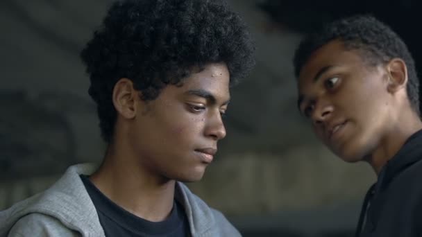 Agresivo afro-americano adolescente amenazando chico en oscuro carril, intimidación — Vídeos de Stock