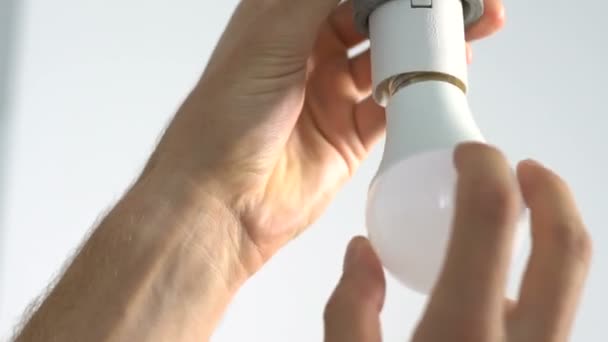 Repairman hands screwing bulb into lampholder, household routine, maintenance — Stock Video