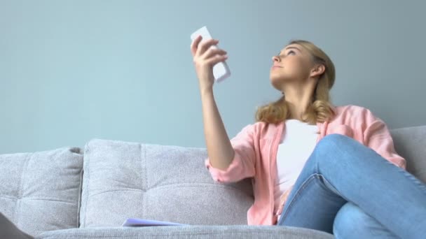 Joven mujer sonriente encendiendo el aire acondicionado y sintiéndose relajado, más fresco — Vídeo de stock