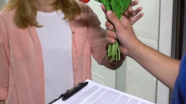 Mulher bonita aceitando entrega de flores e assinando papéis, serviço — Vídeo de Stock