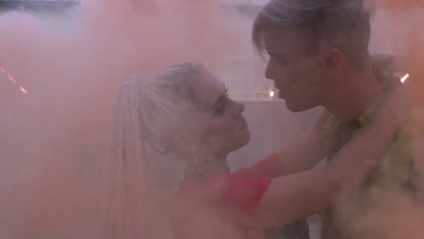 Couple adolescent se reposant et se relaxant dans un nuage de fumée colorée, clubbing, slowmo — Video