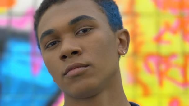 Confident stylish black teen with blue hair and ear ring posing on camera, trend — Stock Video