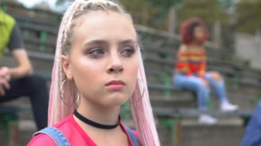 Garip yaşlarda şık bir genç bayan merdivenlerde oturmuş, hayat sıkıntılarını düşünüyor.