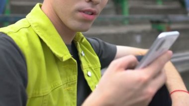 Gadget bağımlısı genç adam sosyal ağları cep telefonuyla dışarıda gezdiriyor, uygulama