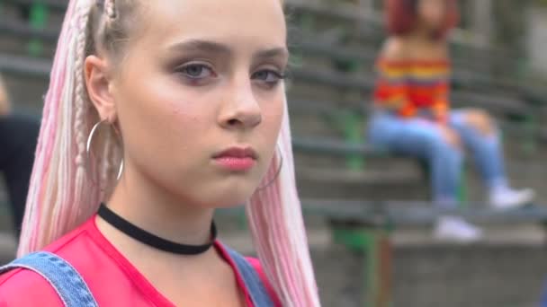 Elegante chica adolescente caucásica en ropa colorida mirando seriamente a la cámara — Vídeos de Stock