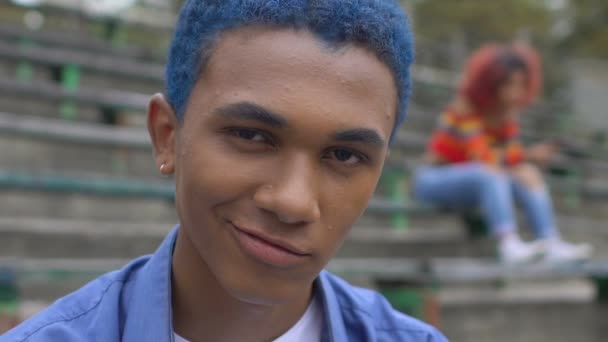 egoistischer schwarzer blauhaariger Teenie-Mann grinst in die Kamera, neue Generation