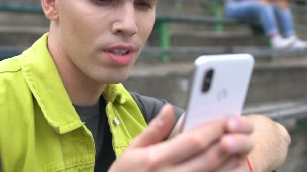 Frusztrált férfi diák néz szörnyű fotó a szociális hálón, gépelés megjegyzés — Stock videók