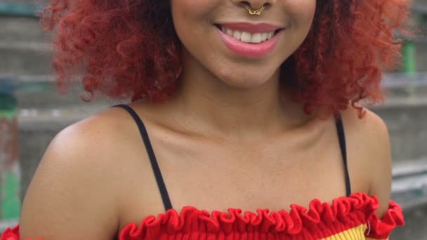 快乐的非洲裔美国红头发年轻女子，鼻孔被刺穿，在镜头前微笑着 — 图库视频影像