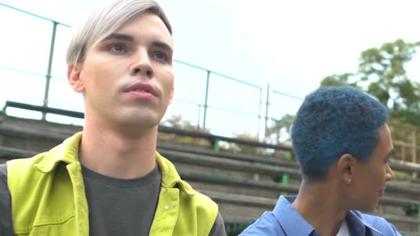 Azul de pelo adolescente masculino con amigo coqueteando con mujeres bonitas al aire libre, simpatía — Vídeo de stock