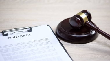 Sözleşme belgesi masada, tokmak ses bloğunda yatıyor, hukuki tavsiye, anlaşma