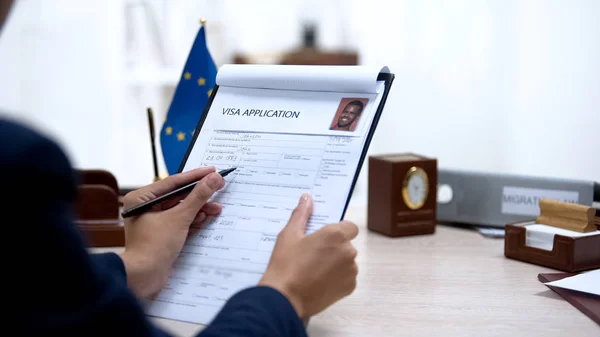 ビザ申請事務所をチェックする大使館職員 テーブルの上の欧州連合旗 — ストック写真