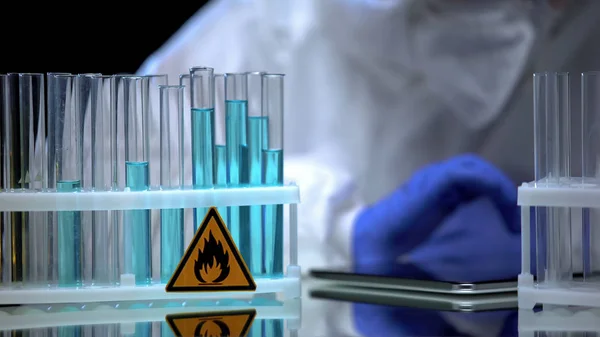 可燃性青色液体充填オンラインレジスタを有する試験管を検討する科学者 — ストック写真