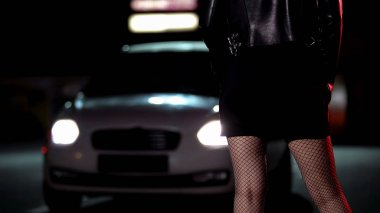 Car driving to prostitute in provocative clothing on dark street, night life clipart