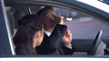 Woman looking at boyfriend drinking alcohol on driver seat, dangerous habit clipart