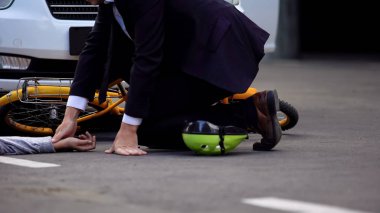 Erkek sürücü yolda araba çarptıktan sonra genç çocuk kurban nabız kontrol, kaza
