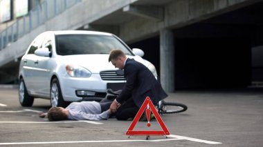 Yolda yol tehlike işareti, adam bilinçsiz bisikletçi arka plan nabız kontrol