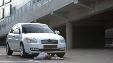 Beyaz otomobil altında bilinçsiz bir yaya, şehir trafik kuralları, yol ihmali