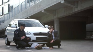 Stresli araba sürücüsü ve kaza kurbanı yalancı yol polisi raporu dolduruyor.