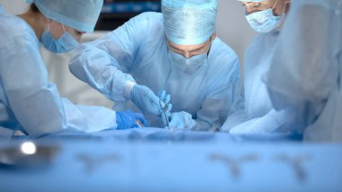 Ameliyat yapan profesyonel cerrah ekibi, masada sterilize edilmiş alet