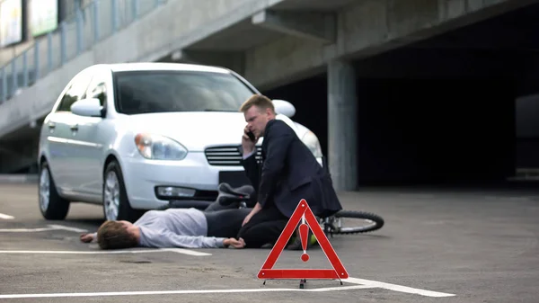 道路上の赤い三角形 自転車で交通事故後に緊急呼び出す男性 — ストック写真