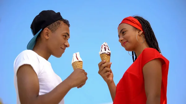 两个拿着甜甜的冰激淋的青少年互相望着对方 从下往下看 — 图库照片