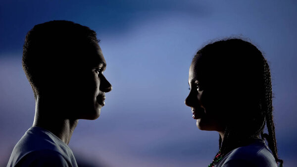Smiling couple silhouettes looking each other, love from first sight, affection