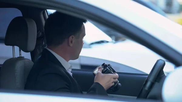 車の中で座っているカメラ付きの私立探偵 不正行為の証拠を探す — ストック写真